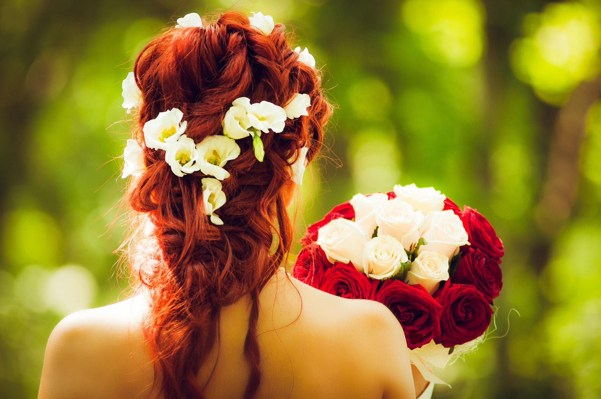 Braut von hinten mit einem rot-weissem Blumenstrauss