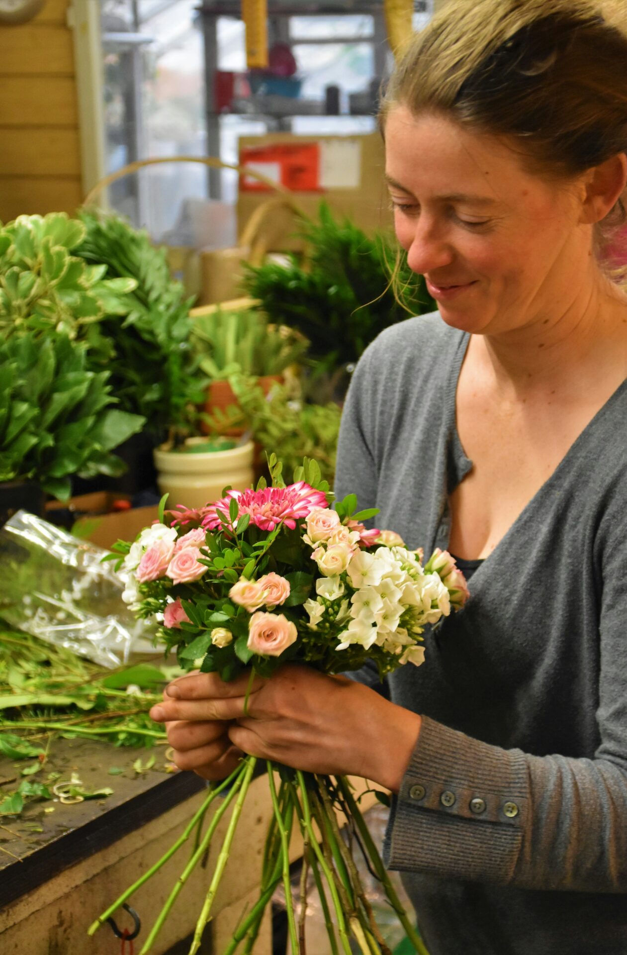 Mitarbeiterin am Blumen zusammenbinden